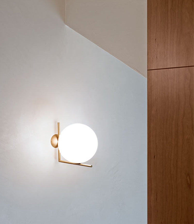 Flos IC Lights Ceiling/Wall Sconce mounted to wall next to wood molding.