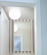 Flos Glo-Ball ceiling sconce mounted above a bathroom mirror.