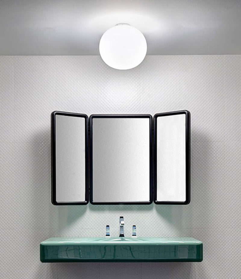 Flos Glo-Ball Ceiling sconce mounted above a bathroom vanity.