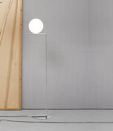 Flos IC Lights Floor Lamp next to a wood panel in an open, grey room.