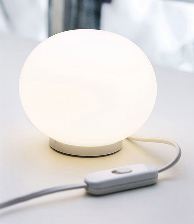 Flos Glo-Ball Basic Zero illuminating a side table, showing white switch on cable.