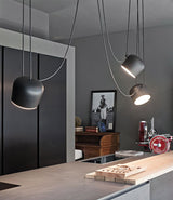 Three Flos Aim suspension lamps hung in sequence above a kitchen counter.
