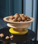 An Alessi Twergi ES15 Centrepiece filled with walnuts, on a small table. 