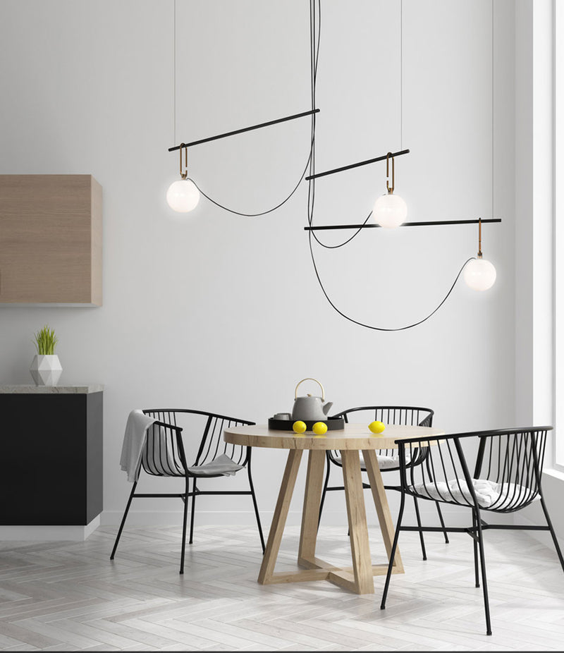 Artemide NH S3 suspension lamp hanging above a small wooden dining table.