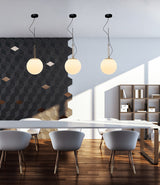 Three Artemide NH suspension lamps hanging above dining table.