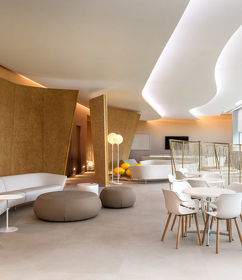 Large lounge area with modern furniture and Artemide Castore floor lamps.