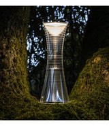 Artemide Come Together table lamp on a mossy tree trunk.
