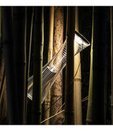 An Artemide Come Together table lamp wedged among bamboo.