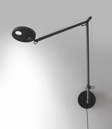Artemide Demetra wall lamp in anthracite grey, mounted to a wall.