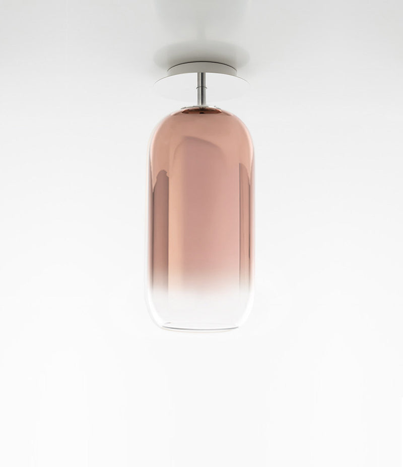Pill-shaped Artemide Gople ceiling lamp, with blown glass diffuser in gradient copper.