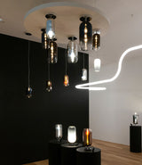 A collection of Artemide Gople ceiling, suspension, and table lamps installed in a room with wood floors.