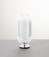 Pill-shaped Artemide Gople table lamp with steel chrome base and blown glass shade in gradient silver.