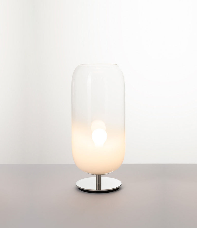 Pill-shaped Artemide Gople table lamp with steel chrome base and blown glass shade in gradient white.