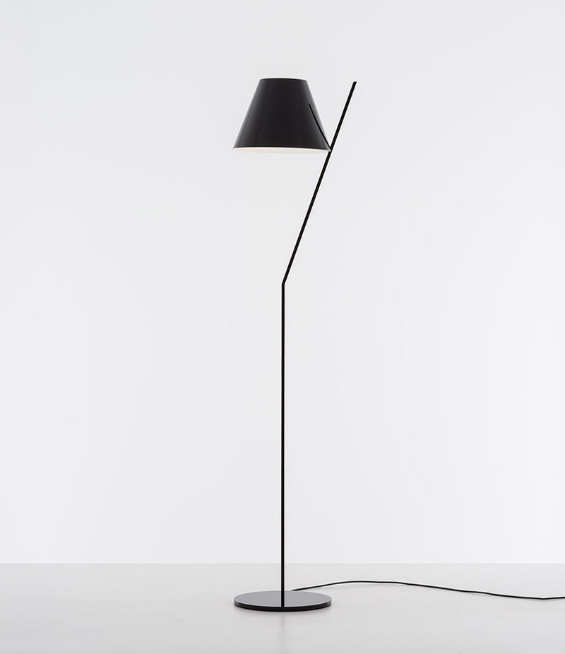 Black Artemide La Petite floor lamp with tilted stem and conical shade.
