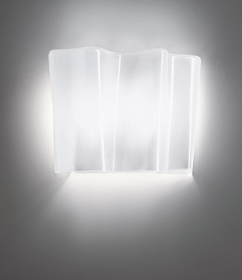 Artemide Logico wall sconce mounted to a wall, with blown glass diffuser shaped into a unique folded pattern.