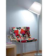 Artemide Melampo floor lamp beside a multicoloured chair.