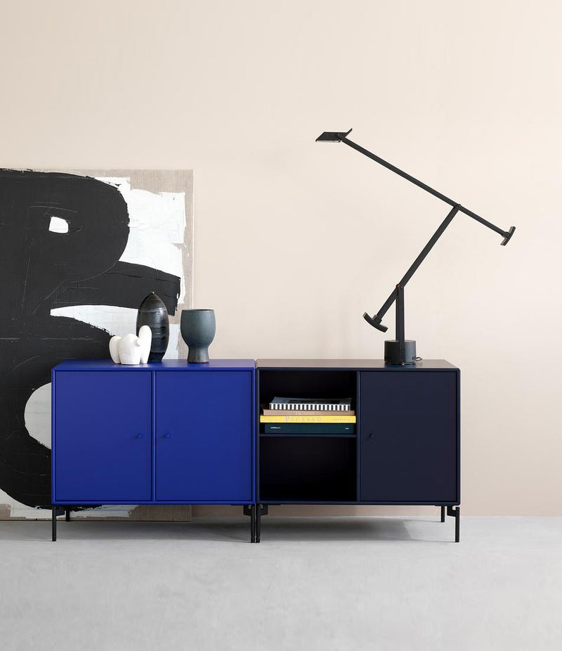 Artemide Tizio table lamp on a multicoloured console in front of a large art canvas.