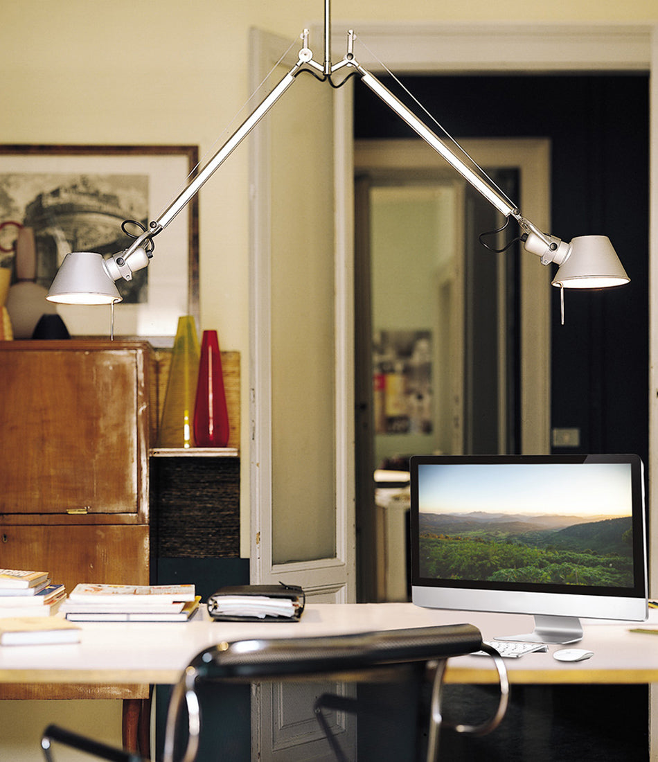 Two Artemide Tolomeo double suspension lamp hangs above a desk and computer in an office.