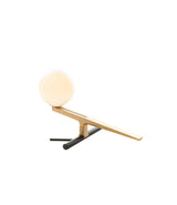 Resembling a small bird, Artemide Yanzi table light is a small spherical diffuser atop a slim brass body.