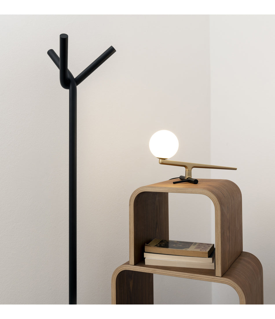Artemide Yanzi table lamp on a wood structure next to a coat rack.