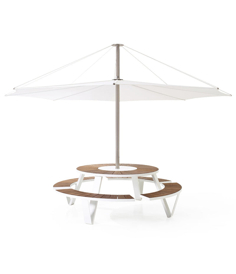 White Extremis Pantagruel picnic table, with dark hellwood slats on circular bench and circular tabletop. Large umbrella mounted in centre.