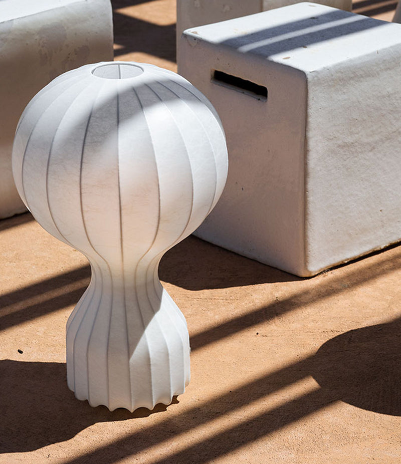 Flos Gatto table lamp on a floor beside white blocks.