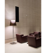Flos KTribe F3 floor lamp next to four leather lounge chairs.