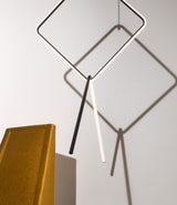 Diamond and V-shaped modules of Flos Arrangements suspension light next to an ornamental wedge.
