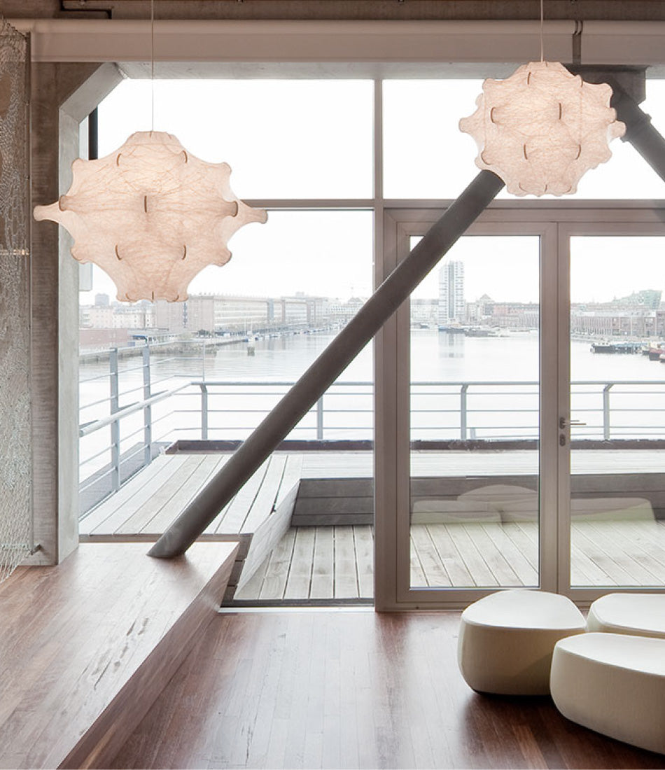 Two Flos Taraxacum 1 suspension lamps hanging over a waterfront living room.