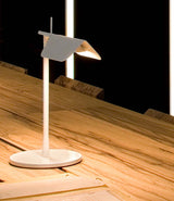 White Flos Tab table lamp on a wooden tabletop. 