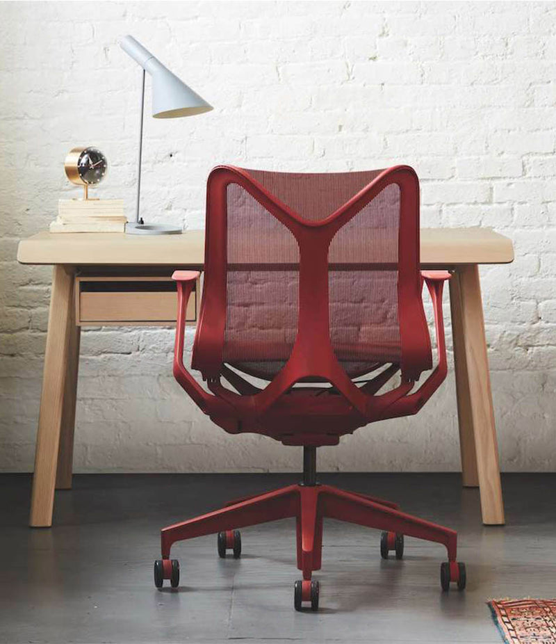 Herman Miller Cosm low back dipped in colour task chair. Canyon finish in front of wooden desk.
