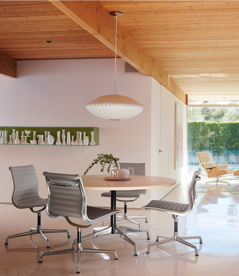A Herman Miller Nelson Saucer Bubble lamp suspended over a dining table.