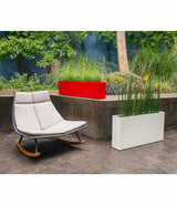 Red gloss Layer All Day aluminum planter and white gloss Everyday planter next to rocking chair in a courtyard.