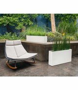 White gloss Layer All Day and Everyday planters next to rocking chair in a courtyard.