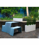 Layer All Day and Everyday planters in white gloss finish next to metal picnic table in a courtyard.